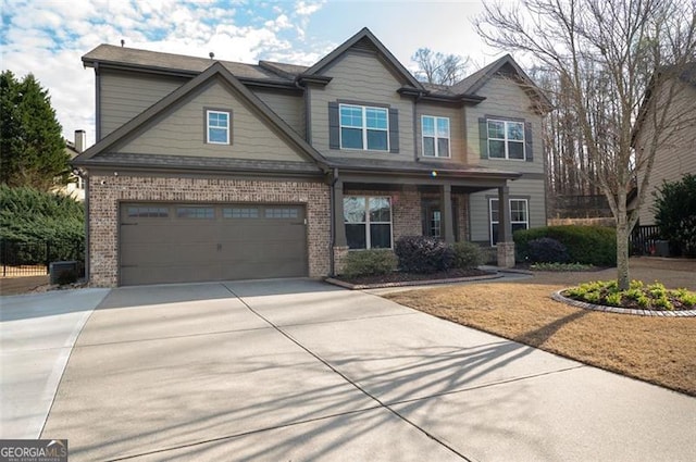 craftsman-style home with a garage, concrete driveway, and brick siding