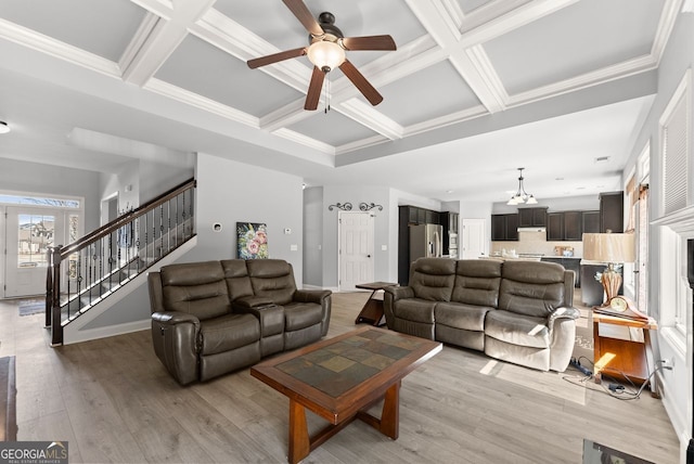 living room featuring crown molding, stairway, coffered ceiling, and light wood-style floors