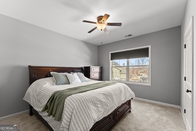 bedroom with light carpet, ceiling fan, visible vents, and baseboards