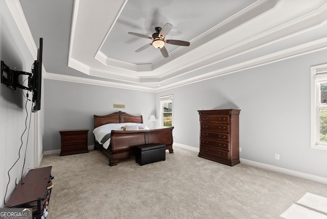 bedroom featuring carpet floors, baseboards, a tray ceiling, and crown molding