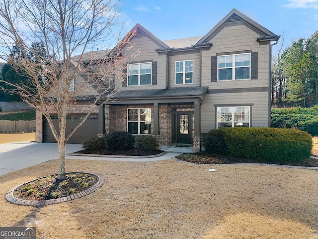 view of front of property featuring a front yard, concrete driveway, and brick siding