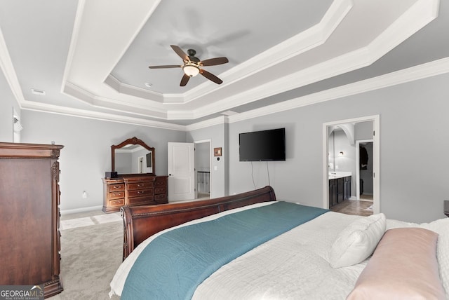 bedroom with light carpet, visible vents, a tray ceiling, and crown molding