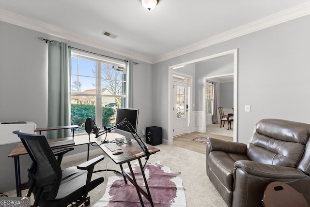 home office featuring a wainscoted wall, visible vents, light wood finished floors, and crown molding