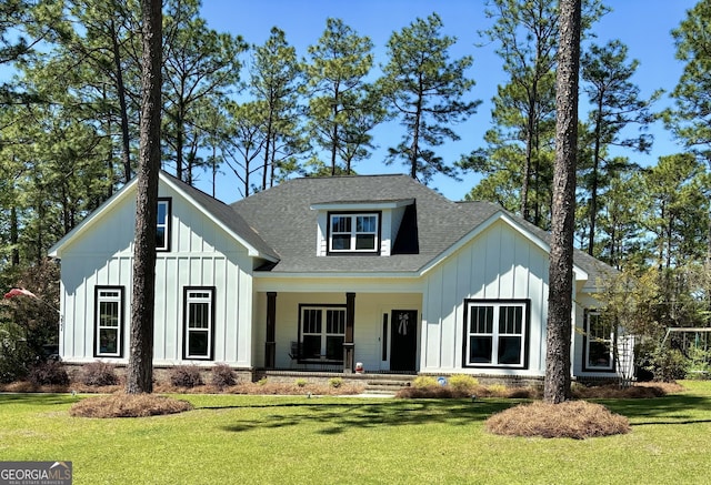 modern inspired farmhouse with covered porch, board and batten siding, a shingled roof, and a front lawn