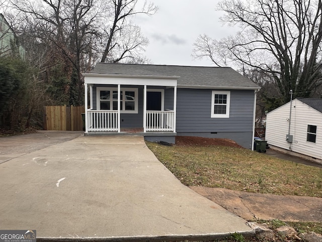 view of front of property with a porch, fence, roof with shingles, crawl space, and a front yard