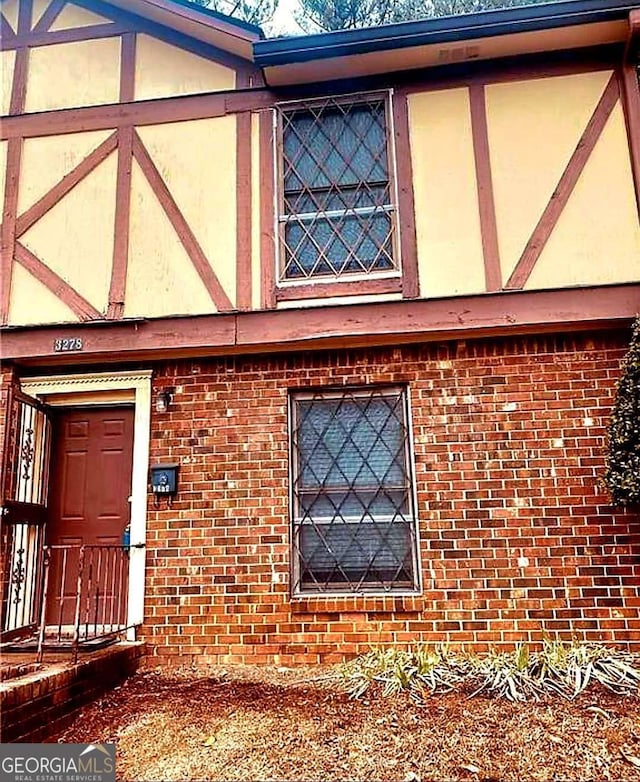 view of property exterior featuring brick siding and stucco siding