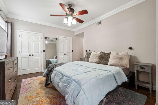 3777 Peachtree Rd NE Unit 911, Atlanta, GA 30319 - bedroom featuring dark wood-style flooring, multiple closets, visible vents, ornamental molding, and ceiling fan