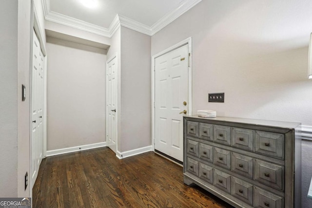 entryway with dark wood-style floors, ornamental molding, and baseboards