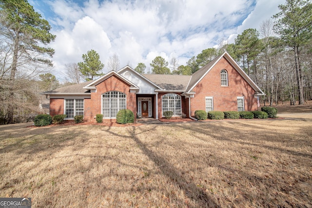 view of front of house with a front yard and brick siding