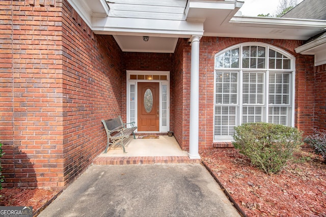 view of exterior entry with brick siding