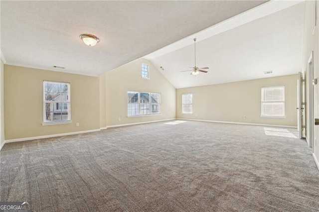 unfurnished living room with carpet floors, a ceiling fan, baseboards, and vaulted ceiling