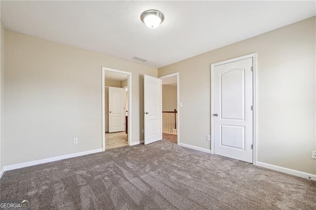 unfurnished bedroom with carpet floors, baseboards, and visible vents