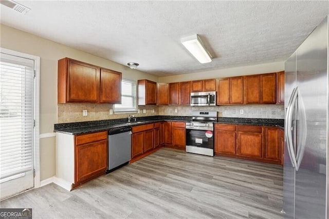 kitchen featuring a sink, brown cabinets, tasteful backsplash, and stainless steel appliances