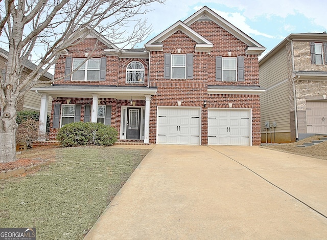 traditional home featuring a garage, a front yard, concrete driveway, and brick siding