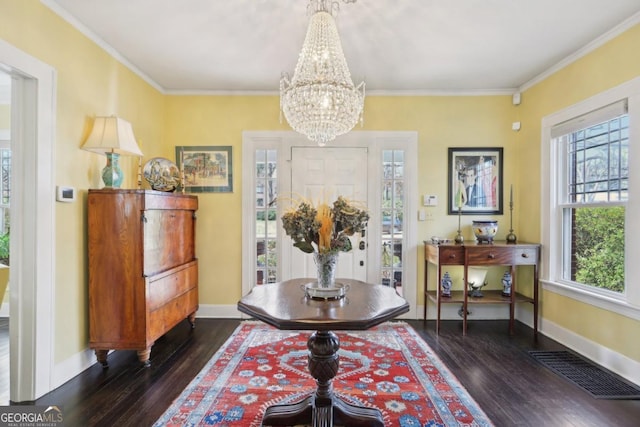 dining space featuring baseboards, visible vents, dark wood-style floors, crown molding, and a chandelier