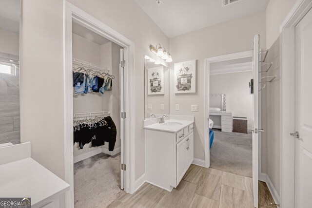 6441 SE Brookside Blvd, Mableton, GA 30126 - ensuite bathroom featuring a walk in closet, connected bathroom, vanity, and baseboards