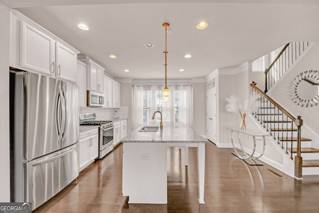6441 SE Brookside Blvd, Mableton, GA 30126 - kitchen with white cabinets, appliances with stainless steel finishes, light stone countertops, a center island with sink, and pendant lighting
