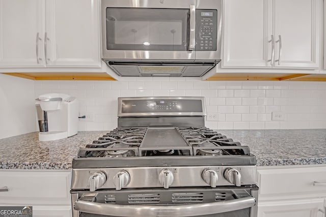 6441 SE Brookside Blvd, Mableton, GA 30126 - kitchen featuring stainless steel appliances, stone counters, white cabinetry, and decorative backsplash