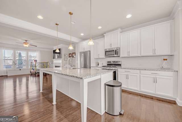 6441 SE Brookside Blvd, Mableton, GA 30126 - kitchen with stainless steel appliances, white cabinets, decorative light fixtures, and a center island with sink