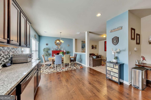 dining room featuring a toaster, baseboards, a chandelier, and dark wood-type flooring