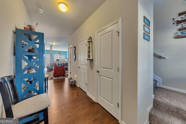 hall featuring baseboards, stairway, and dark wood-style flooring