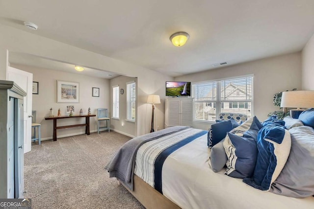 bedroom with baseboards, visible vents, and light colored carpet