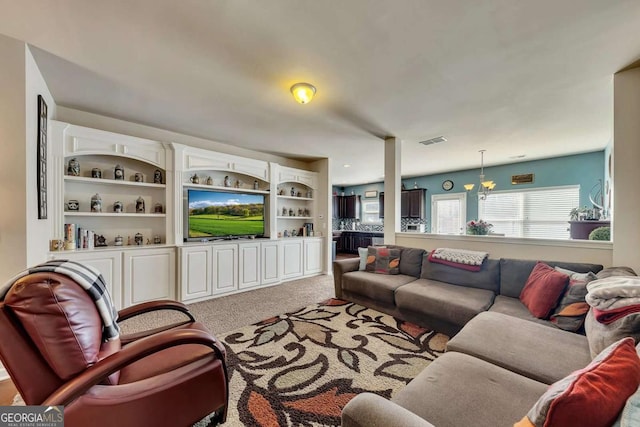 living room featuring visible vents, a notable chandelier, and light carpet