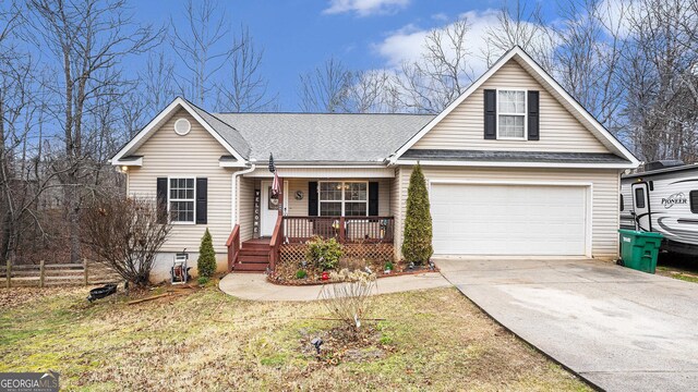 view of front of property with driveway, roof with shingles, an attached garage, fence, and a porch