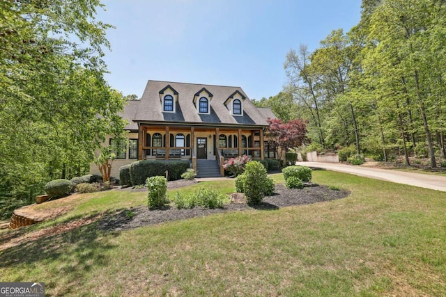 cape cod house featuring driveway, covered porch, and a front yard