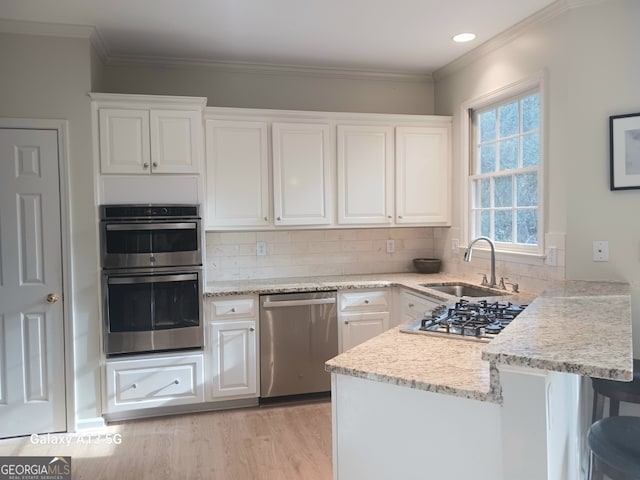 kitchen featuring stainless steel appliances, a sink, and white cabinetry