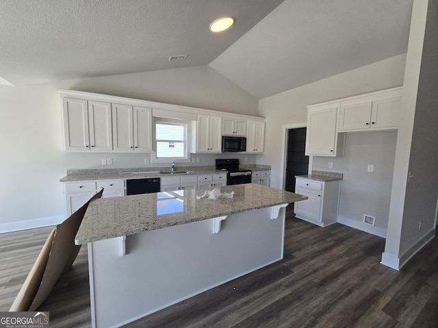 kitchen with visible vents, white cabinets, black appliances, and a sink