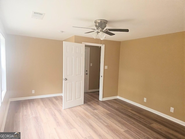 unfurnished bedroom featuring light wood-style flooring, visible vents, ceiling fan, and baseboards