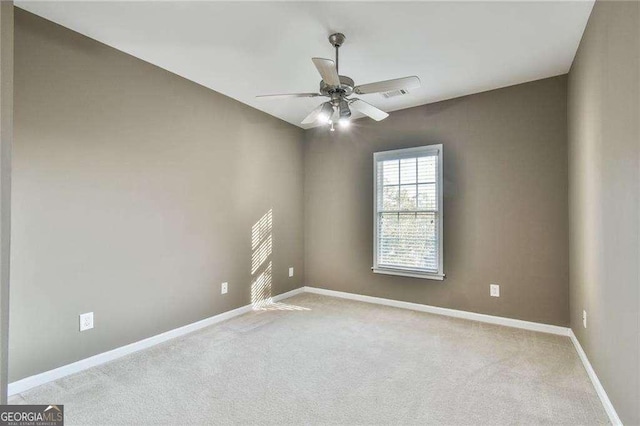 unfurnished room featuring light carpet, baseboards, visible vents, and a ceiling fan