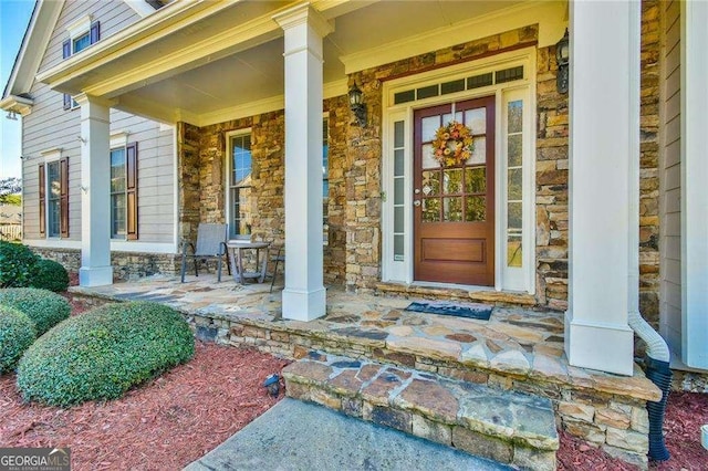 property entrance with a porch and stone siding