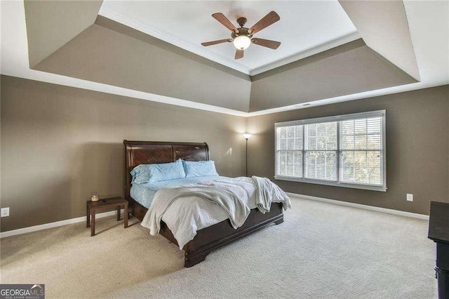 carpeted bedroom with crown molding, ceiling fan, a raised ceiling, and baseboards