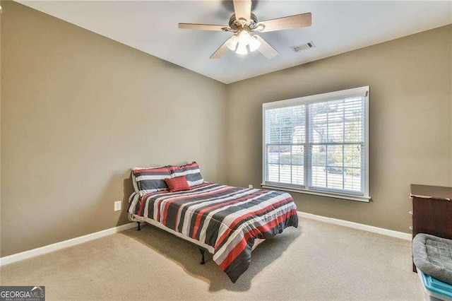 bedroom with light carpet, ceiling fan, visible vents, and baseboards