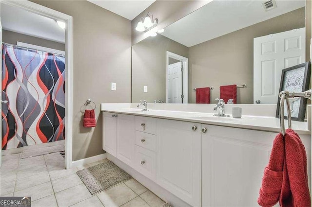 bathroom featuring double vanity, tile patterned flooring, visible vents, and a sink