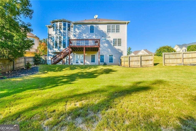 back of property featuring a fenced backyard, a lawn, a wooden deck, and stairs