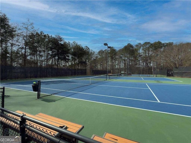 view of sport court featuring fence