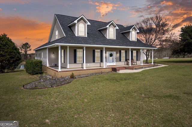 farmhouse inspired home featuring covered porch, roof with shingles, and a front yard