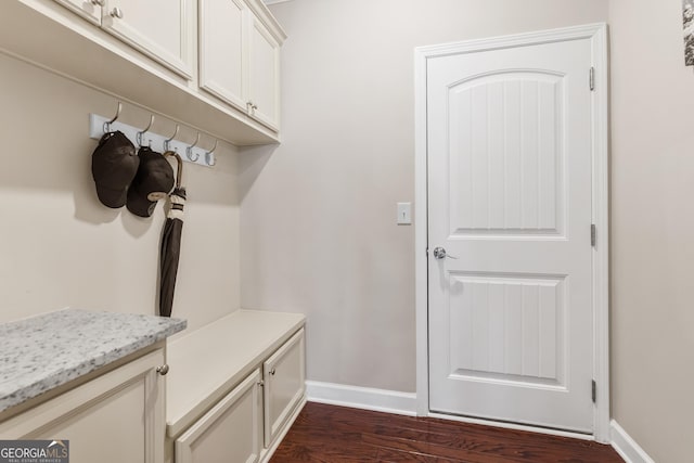 mudroom with dark wood-style flooring and baseboards