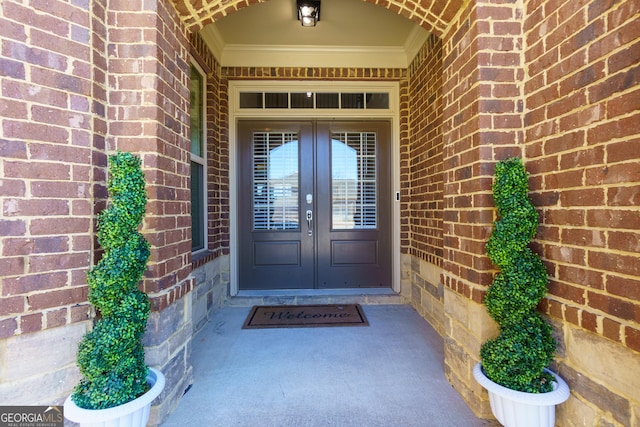 doorway to property featuring brick siding and french doors