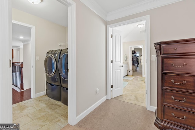 hallway with light colored carpet, baseboards, crown molding, and washing machine and clothes dryer