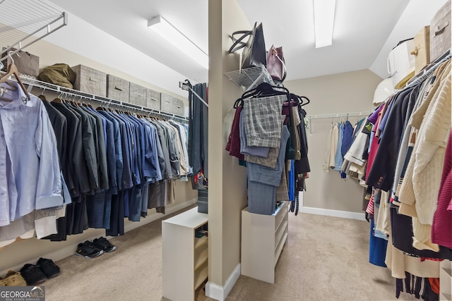 walk in closet featuring light carpet and vaulted ceiling