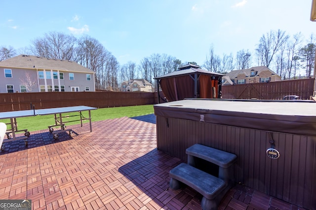 view of patio / terrace featuring a gazebo, a fenced backyard, a residential view, and a hot tub