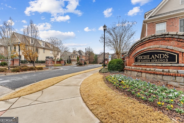 view of road featuring sidewalks, street lighting, a residential view, and curbs