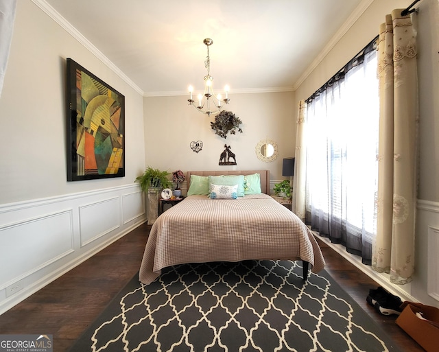 bedroom with wainscoting, wood finished floors, an inviting chandelier, crown molding, and a decorative wall