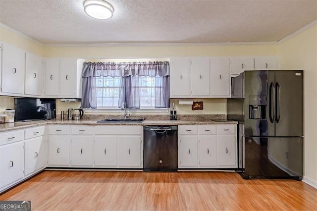 kitchen featuring white cabinets, light wood-style flooring, a textured ceiling, black appliances, and a sink