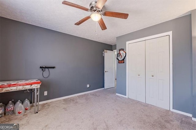 unfurnished bedroom with a closet, light colored carpet, a textured ceiling, and baseboards