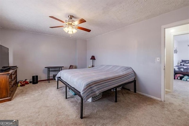 bedroom with baseboards, a ceiling fan, a textured ceiling, and light colored carpet